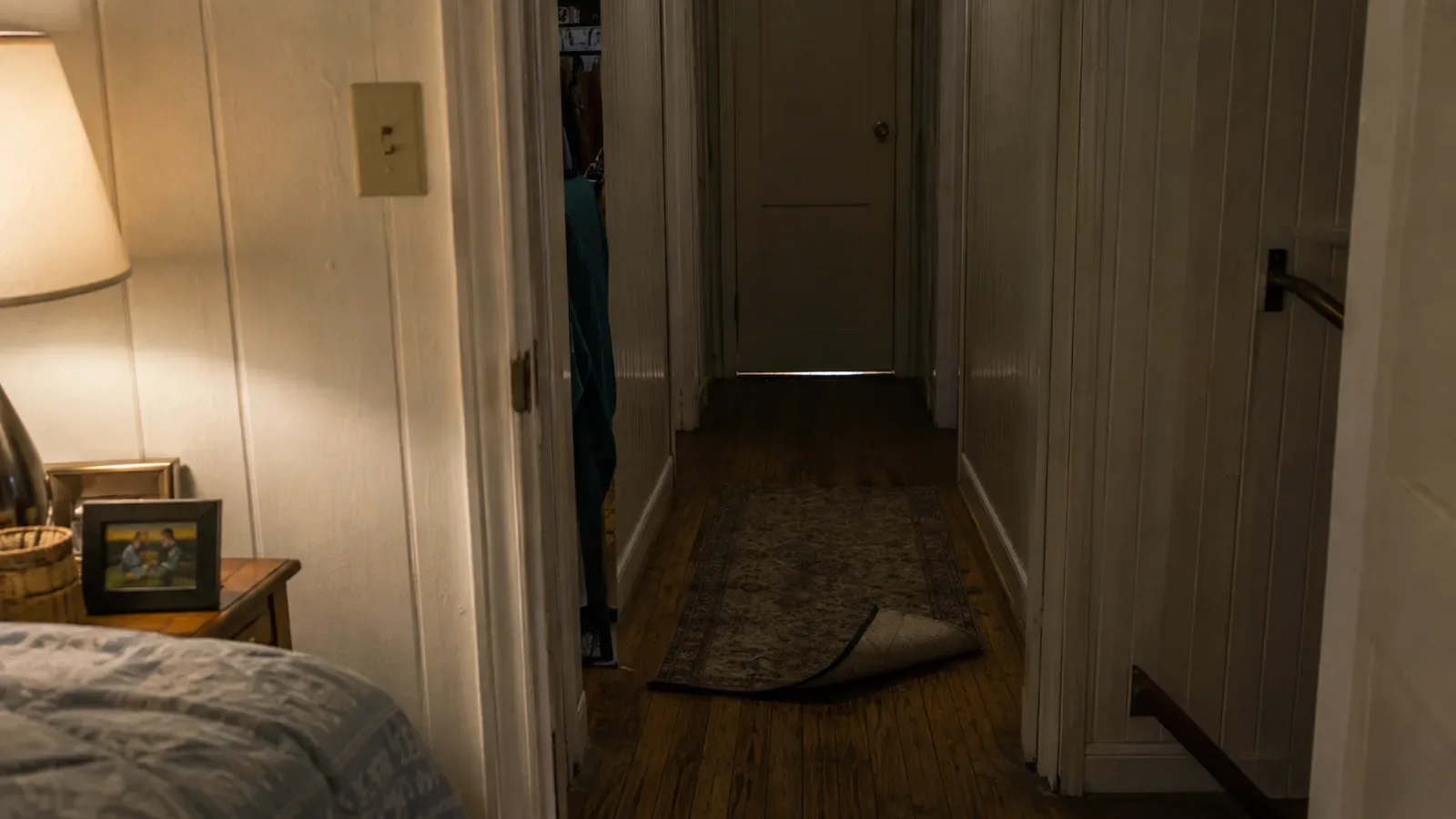 Unlit hallway with a loose throw rug, a common fall hazard in older New Jersey homes